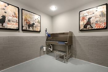 A room with a sink and two paintings on the wall.